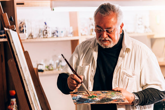 old man artist painting oils in his studio